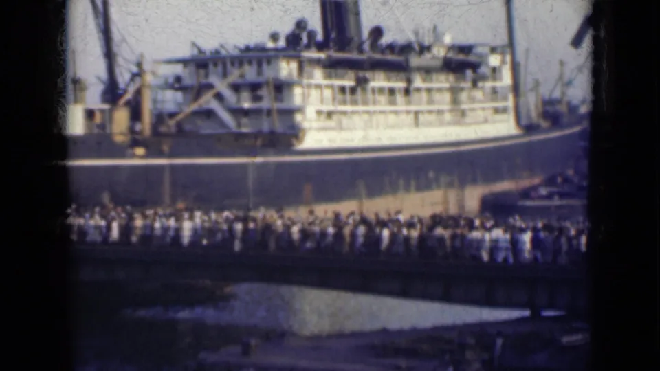 1947 India home-movie view of a crowded port bridge beside a large passenger vessel.