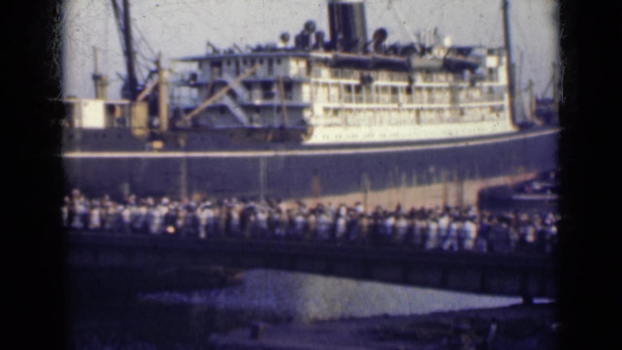 Crowd crossing a bridge toward a large docked ocean liner.