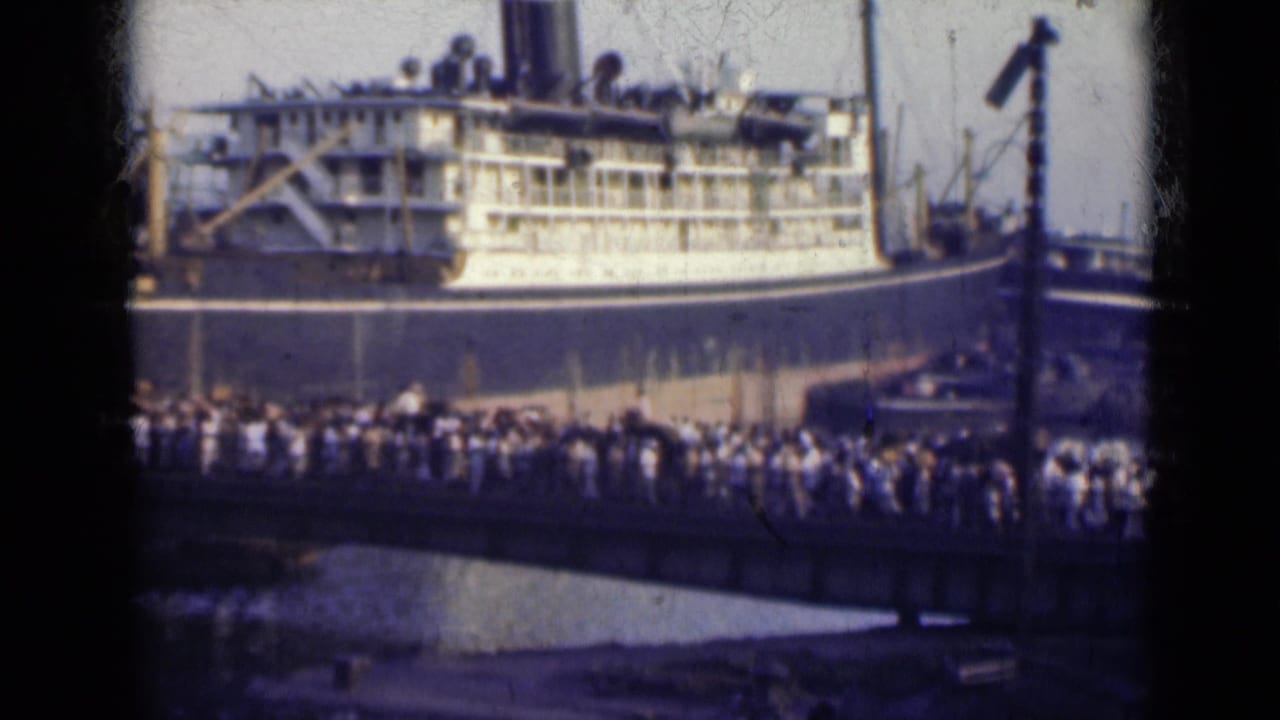 Crowd gathered on a dock beside a large passenger ship.