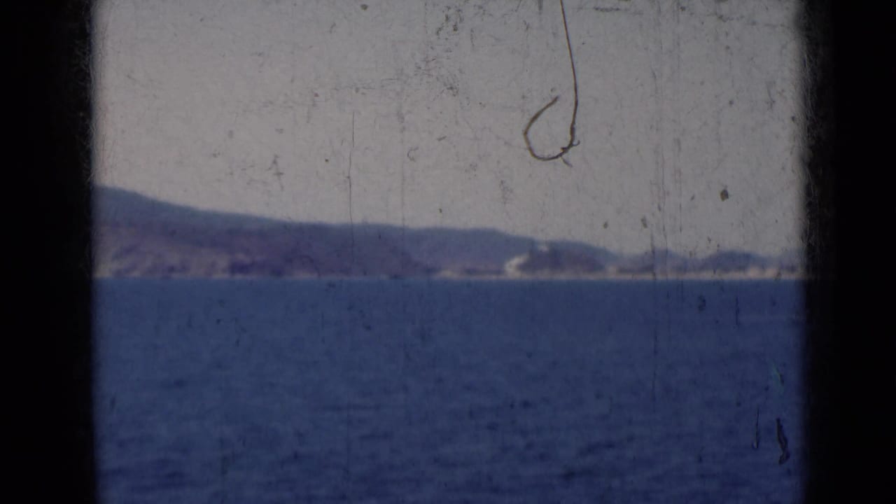 Blue ocean with a hazy coastline and low hills in the distance.