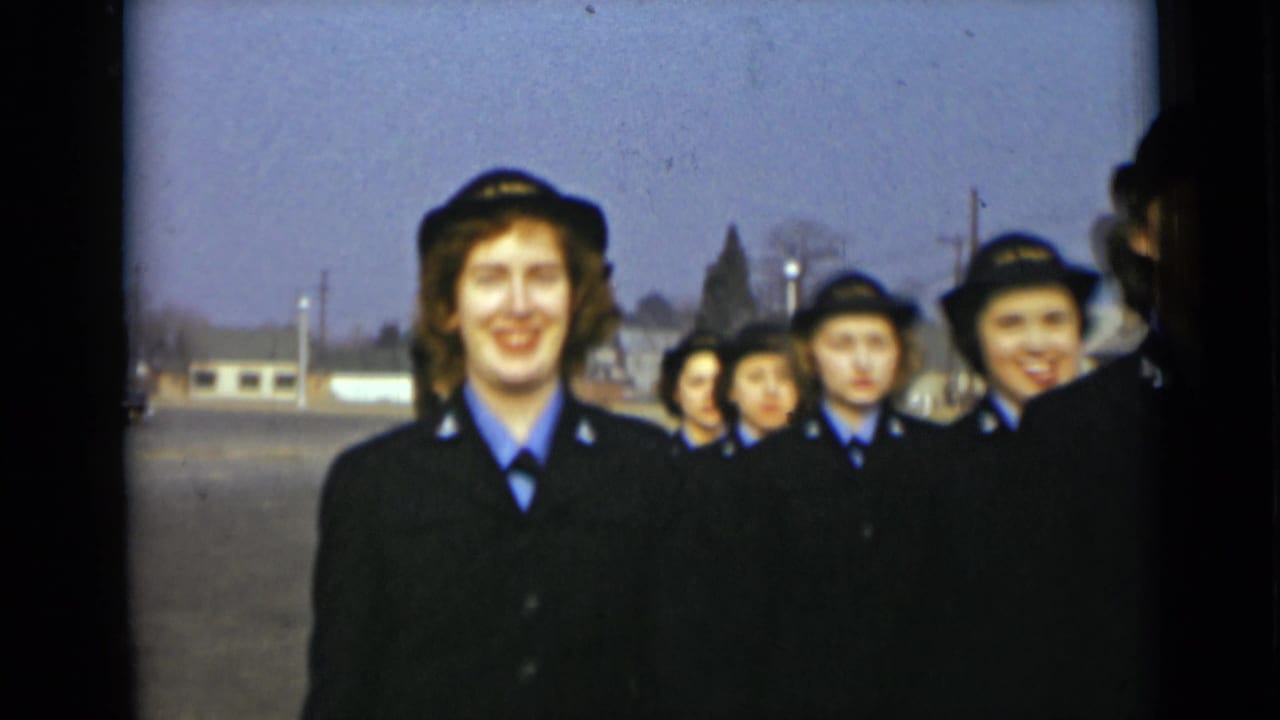 A smiling young woman in a dark uniform leads others in matching hats and coats in 1947 New York home-movie footage.