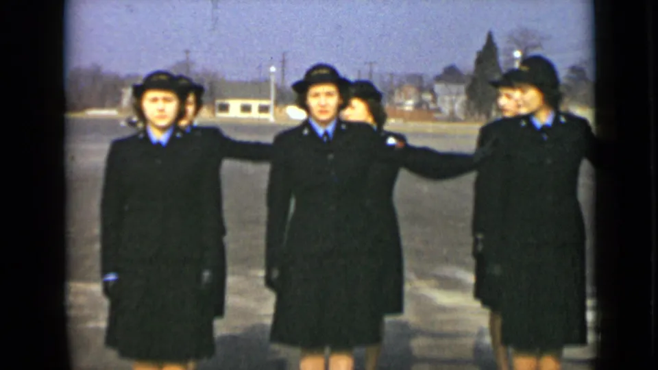 At the end of the clip, uniformed women gather close as one extends an arm across the formation during the drill.