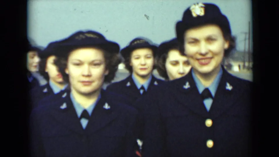 A close 1947 New York frame shows uniformed women near the camera, including a smiling woman with visible insignia.