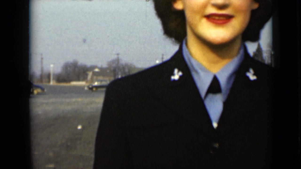 Close view of a woman in a dark uniform and light blue shirt, partly cropped at the face.