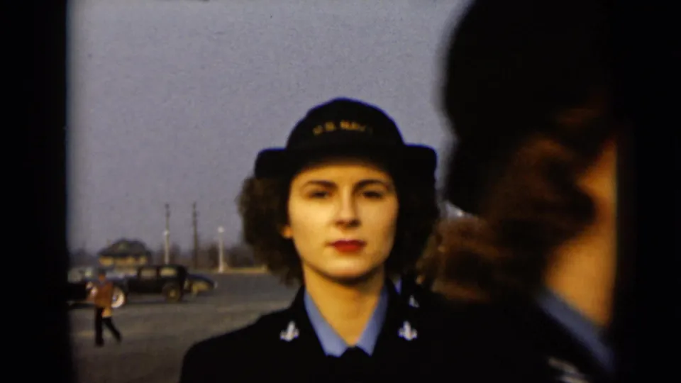 1947 New York frame showing a uniformed woman facing the camera as another uniformed figure passes close in the foreground.
