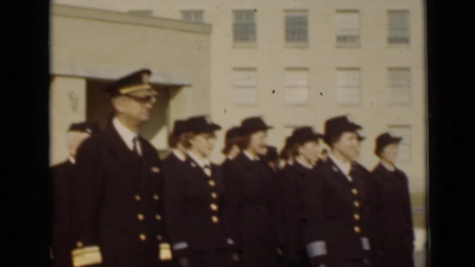 A male officer in dress uniform stands near a line of uniformed women during the New York military-style ceremony.
