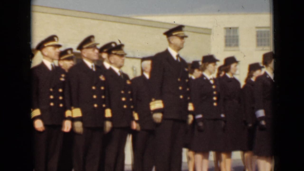 The camera view shifts along a line of sailors and servicewomen in dark uniforms standing at attention in New York, 1947.