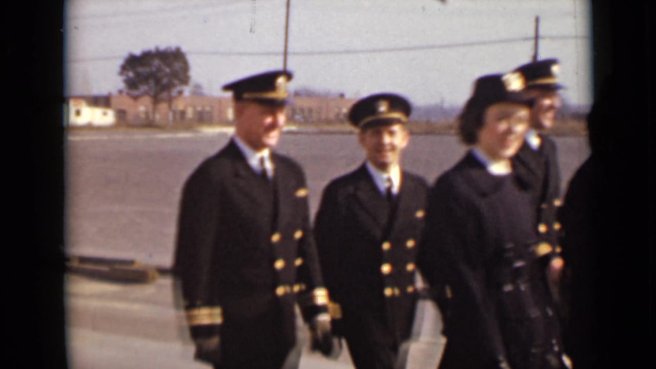 Uniformed adults stand and walk outdoors, some smiling toward the camera.