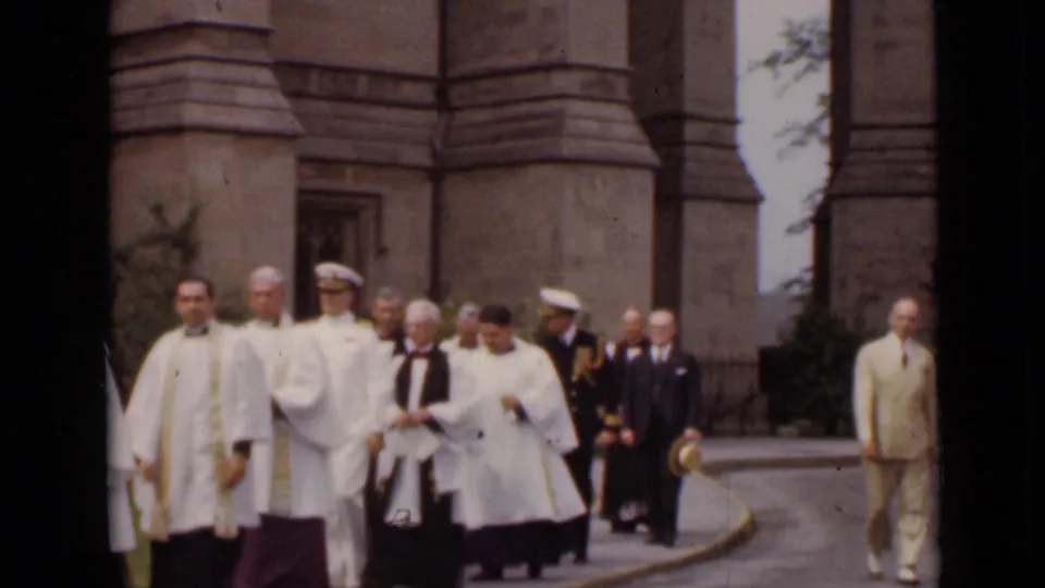 A light-suited man walks near clergy and uniformed officers during a 1947 New York church procession.