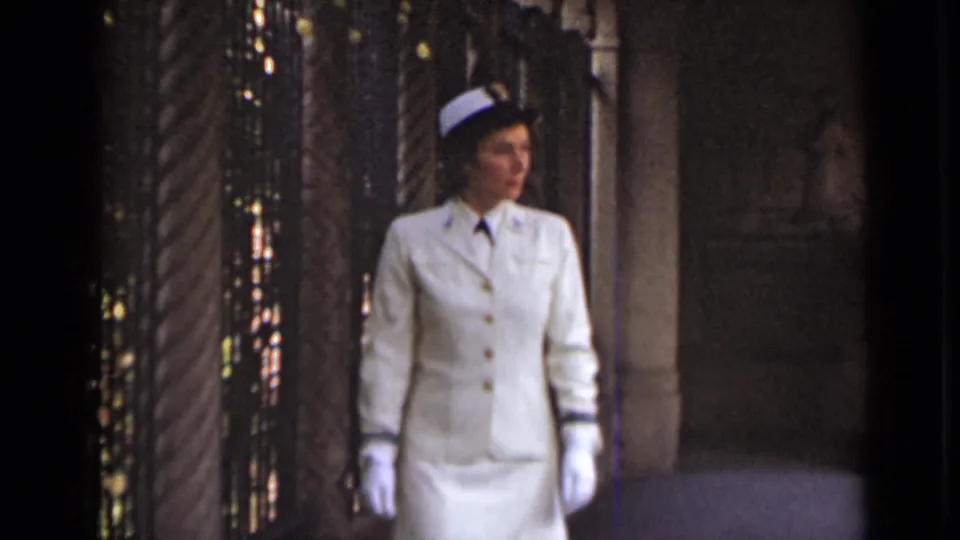 1947 New York footage shows a uniformed woman in white gloves walking through an ornate interior with columns and a dark screen.