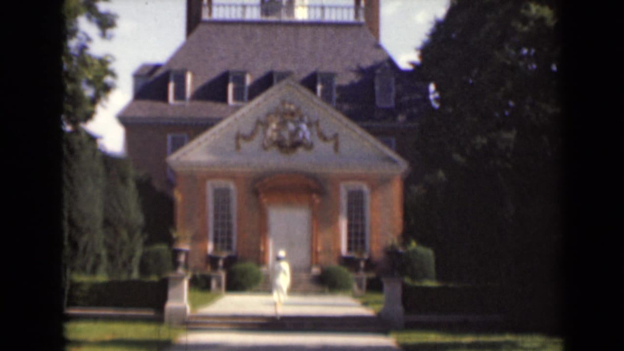 Woman in a light dress walking toward an ornate brick building entrance.