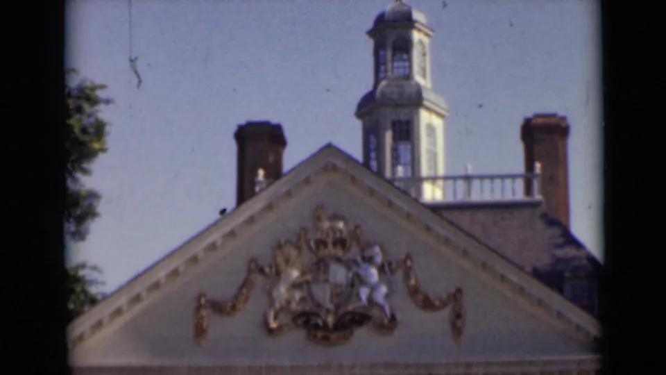 Close 8mm view of the building's triangular pediment with crest ornament and a cupola rising above the roofline in New York, 1947.
