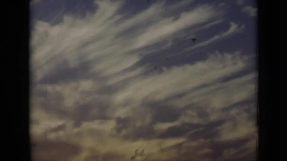 1947 New York 8mm frame showing streaked clouds, muted blue-purple sky, and warmer light near the lower edge.