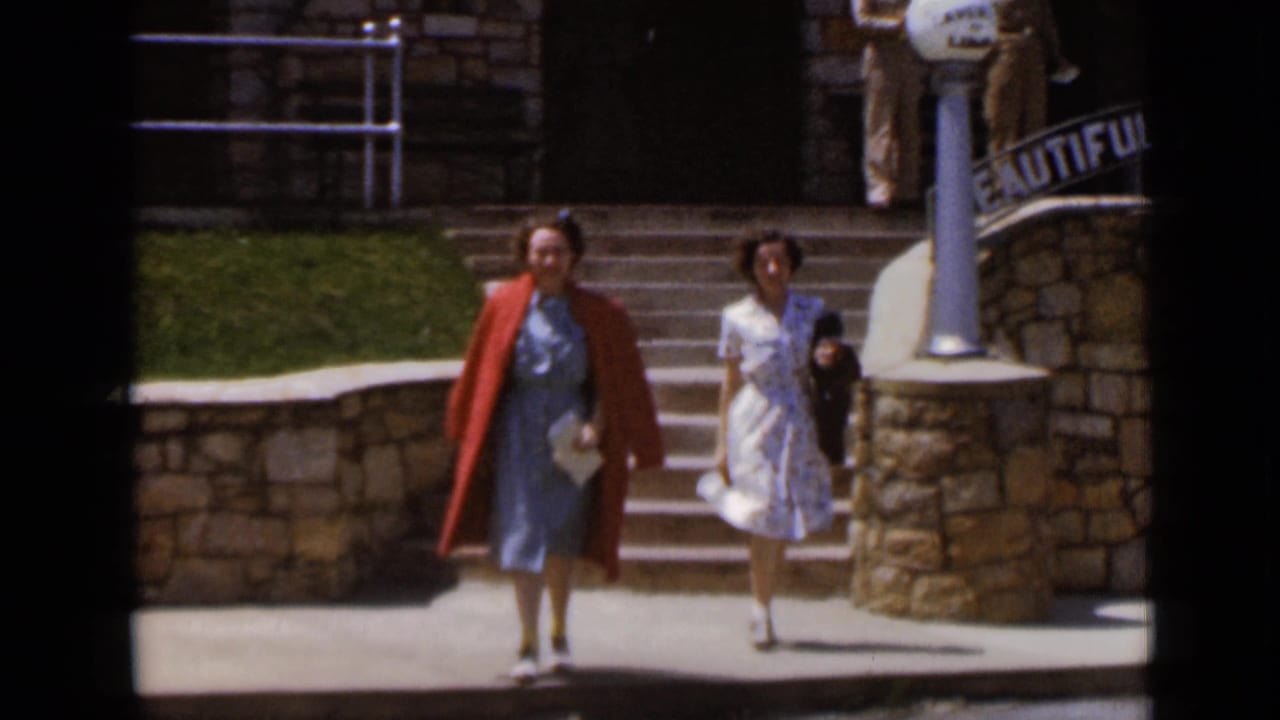 Two women walk down steps near a curved sign reading Beautiful Caverns of Luray.