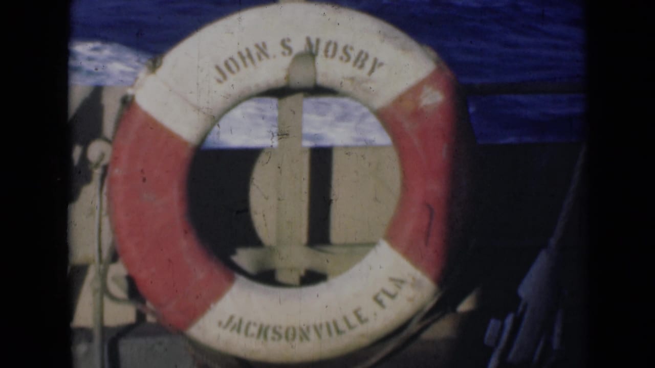 Close view of the John S Mosby life preserver with Jacksonville Fla lettering against water and boat structure.