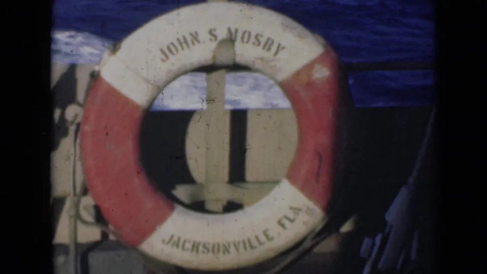 Close 8mm view of the John S Mosby life preserver on a boat, with Jacksonville Fla visible along the lower ring and blue water beyond.