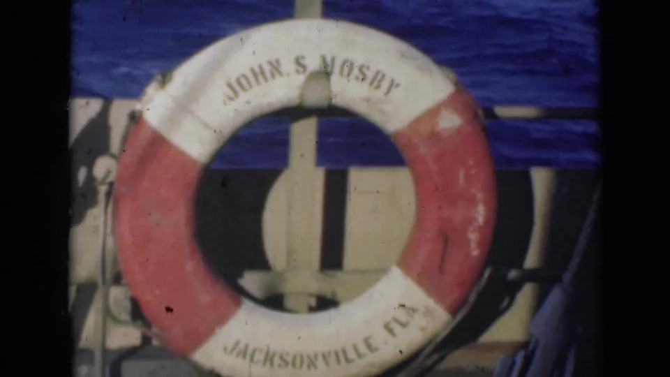 Soft 1947 8mm frame where the red and white John S Mosby life preserver dominates the view, with Jacksonville Fla partly visible below.