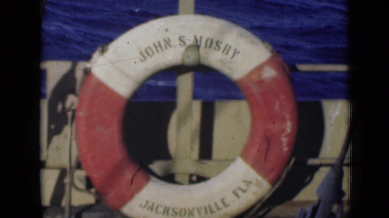 Red and white life preserver ring mounted on a vessel with painted lettering.