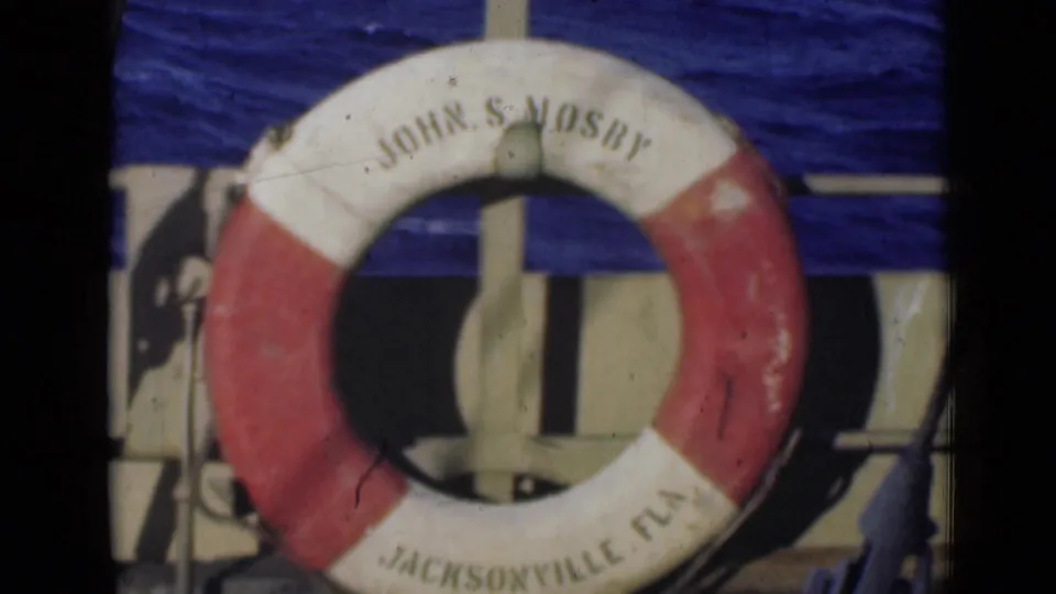 A red and white life ring labeled "JOHN S. MOSBY" and "JACKSONVILLE, FLA." mounted against ship structure in 1947 8mm footage.