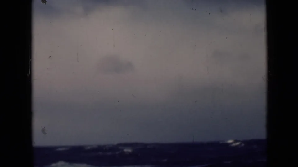 1947 8mm footage frame showing rough open water and a low horizon beneath a gray sky, viewed through dark film borders.