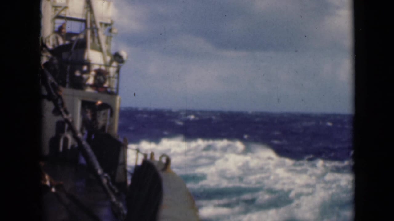 Boat side and bow alongside foamy waves on open water.