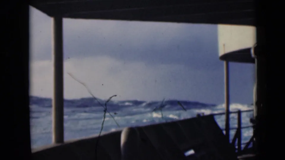 1947 8mm view from a ship deck, showing choppy Persian Gulf waves through silhouetted railings and supports.
