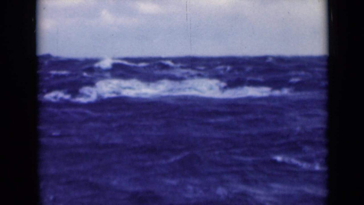 Choppy blue water with whitecaps along the horizon under cloudy sky.