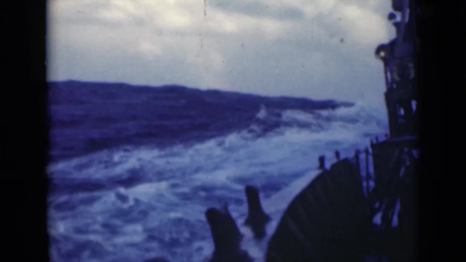1947 8mm frame appears to show a ship moving through rough open water, with deck railings and dark waves visible ahead.