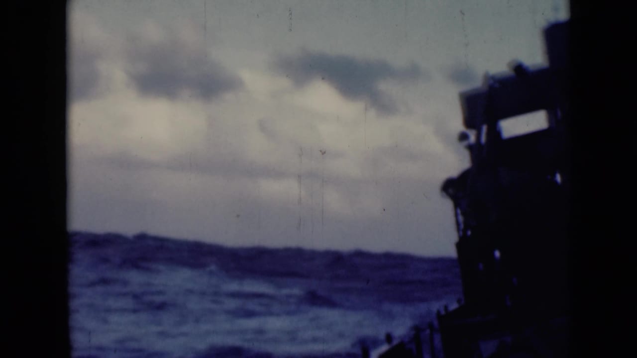 Choppy open water and cloudy sky with the ship silhouette along the right edge.