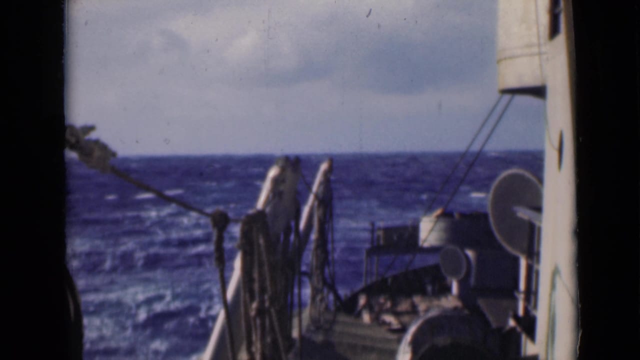 Open water beyond ship railings, rigging, and rounded deck equipment.