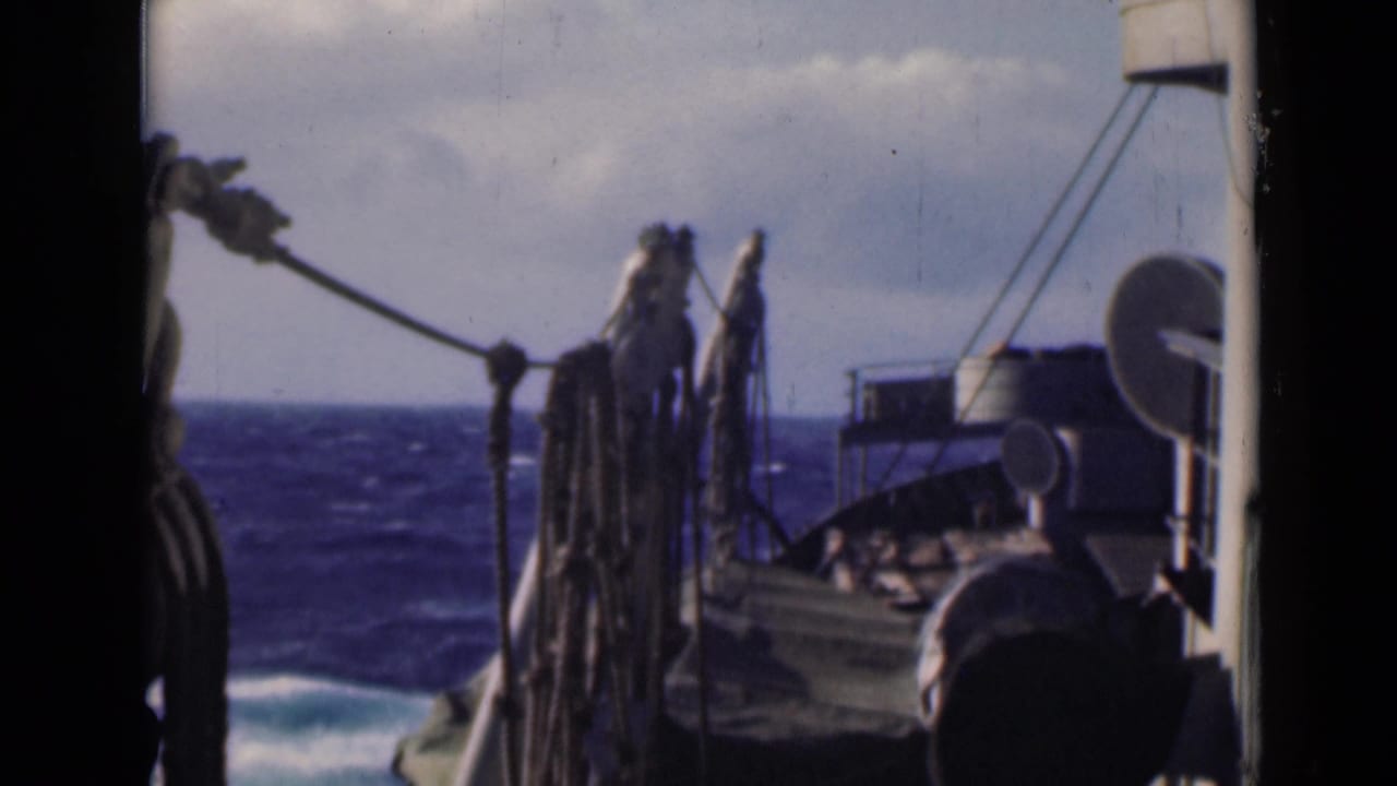 Deck rigging and hanging ropes frame a rough sea under clouds.
