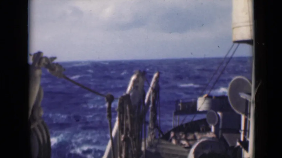 1947 8mm shipboard view over blue Persian Gulf water, with whitecaps, rigging, and deck hardware visible near the frame edges.