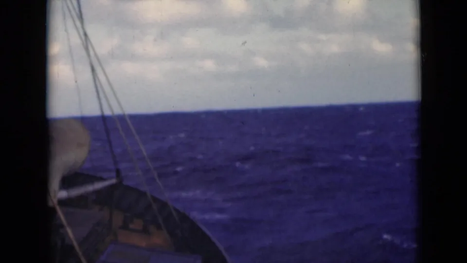 The final frame holds on the sailboat bow and rigging at the edge of the shot, with rough open water filling the view.
