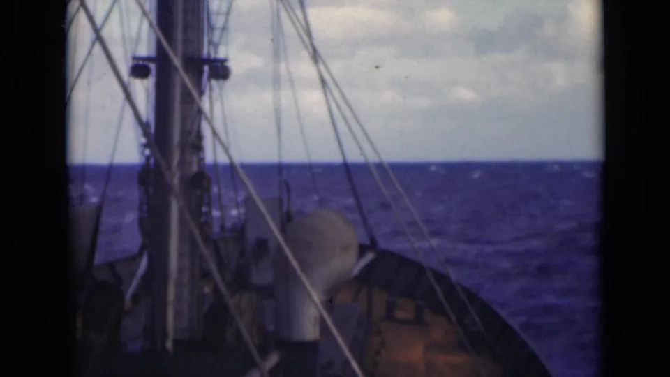 Cataloged 1947 Persian Gulf deck view showing mast, rigging, rounded deck equipment, and rough open water.