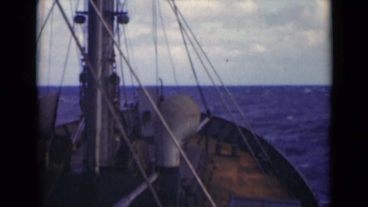Forward deck view from a vessel in the Persian Gulf context supplied by metadata, with mast rigging, bow surfaces, and choppy blue water ahead.