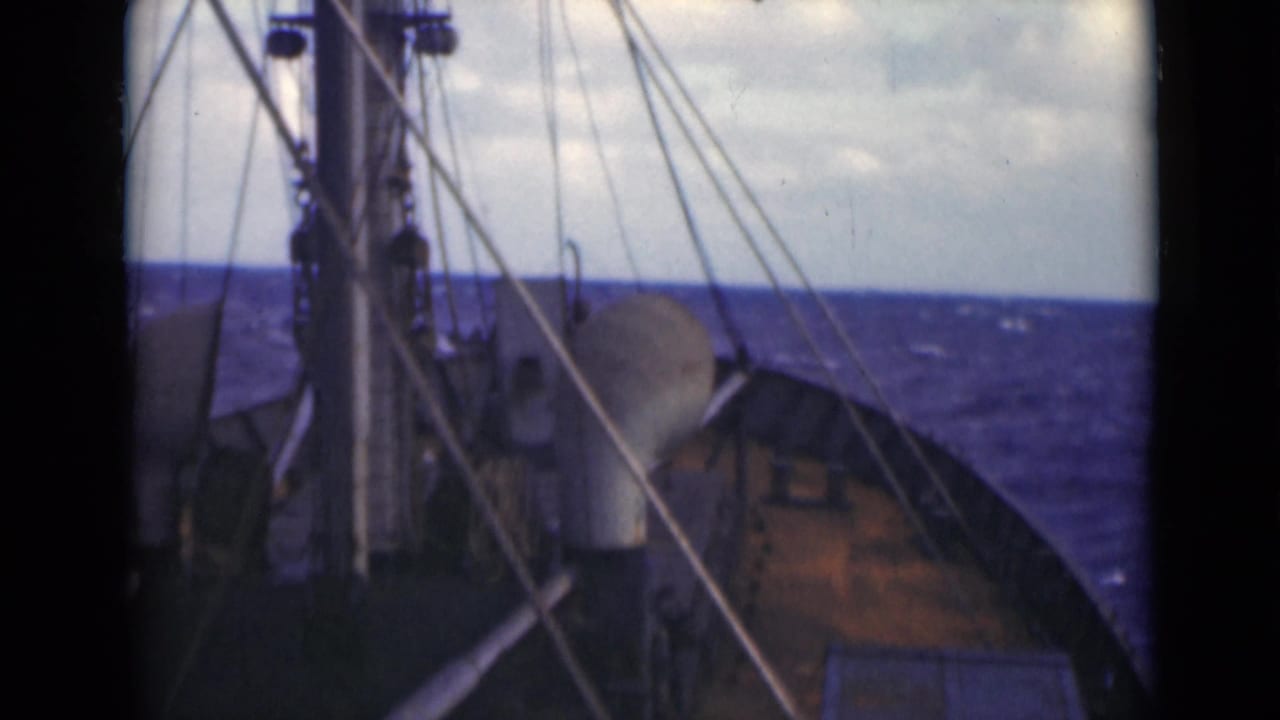 A steady 8mm frame looks past deck fittings and rigging toward choppy open sea, with no people or shore visible.