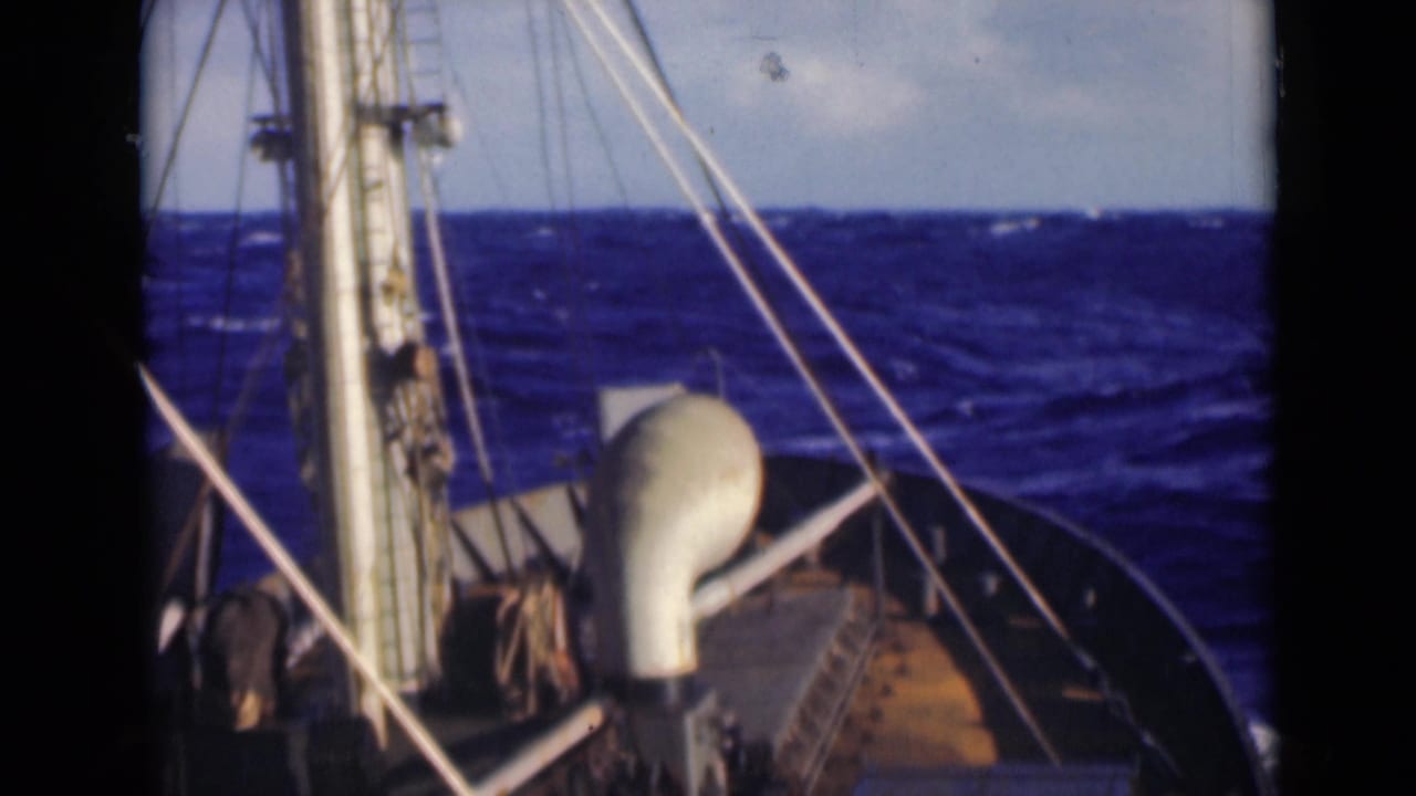 1947 shipboard frame showing rigging and a rounded white deck fixture against dark blue rough seas.
