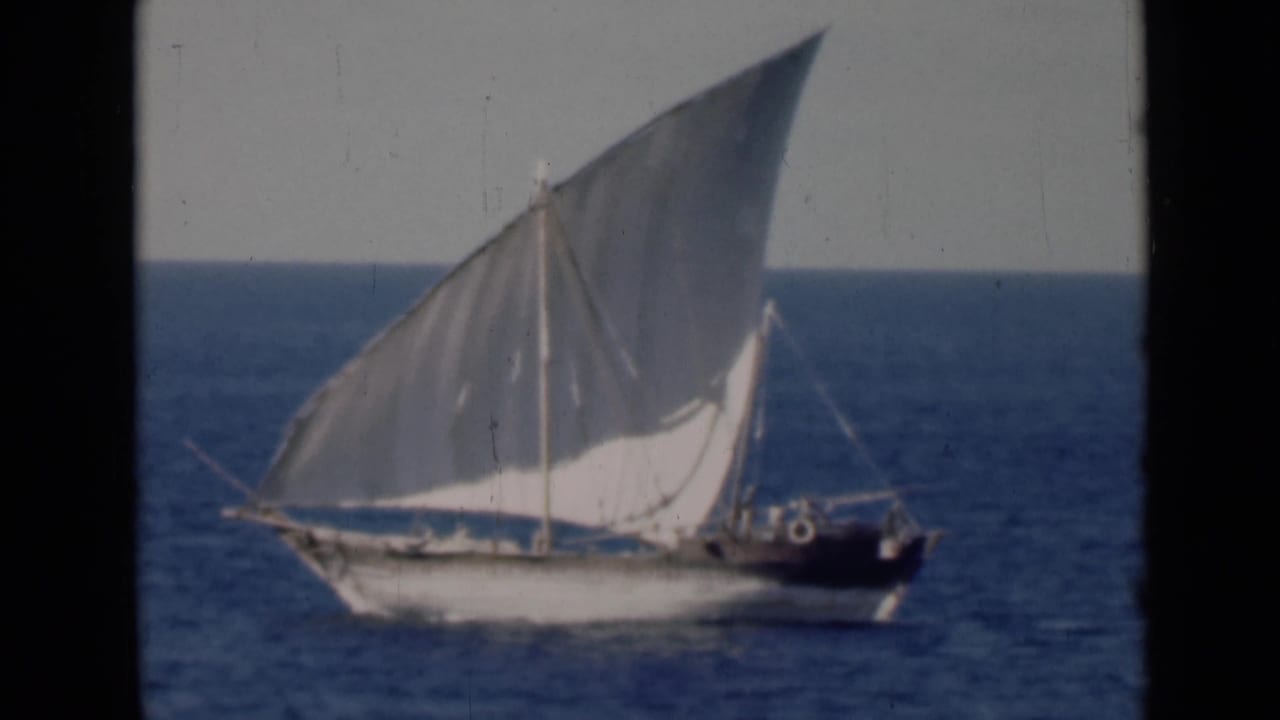 The dhow continues across the frame, its lateen sail prominent against sea and pale sky in the 1947 clip metadata context.