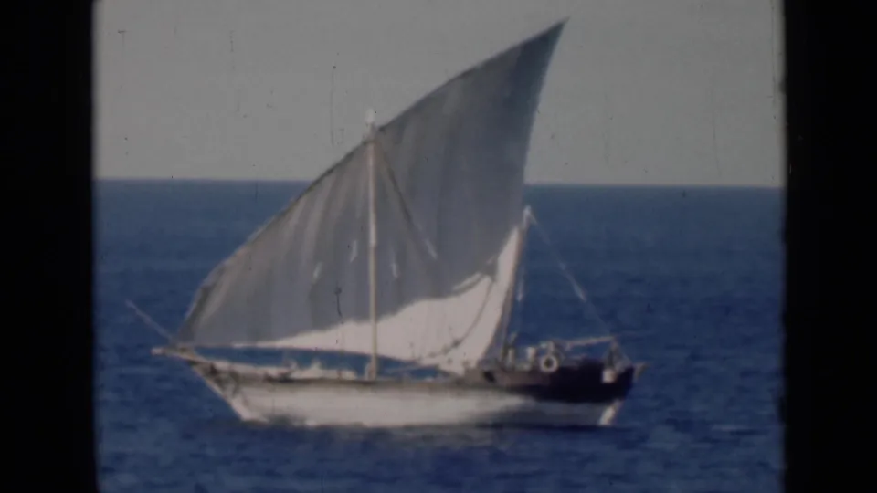 The dhow continues across the frame, its lateen sail prominent against sea and pale sky in the 1947 clip metadata context.