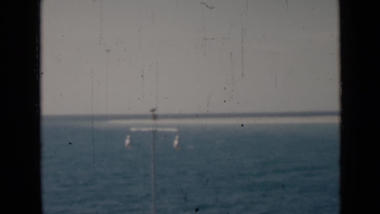 Ocean horizon with several faint lamp posts seen through a dark central divider.
