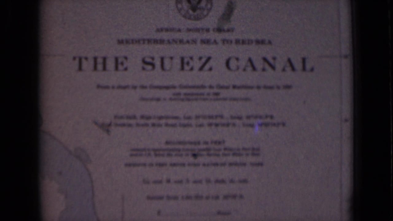 Suez Canal plaque with title, emblem, route text, and partial map outline.