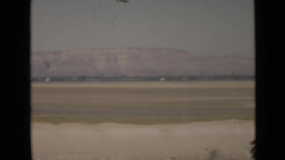 1946 Suez Canal region desert terrain with hazy distant hills, viewed through a dark window or vehicle frame.