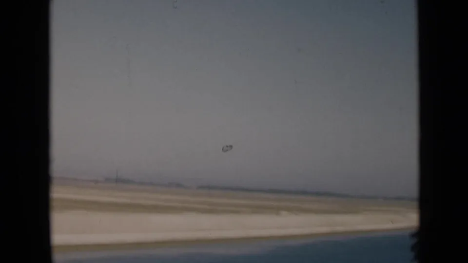 1946 Suez Canal, Egypt home-movie view of a flat desert road and hazy horizon from inside a moving vehicle.