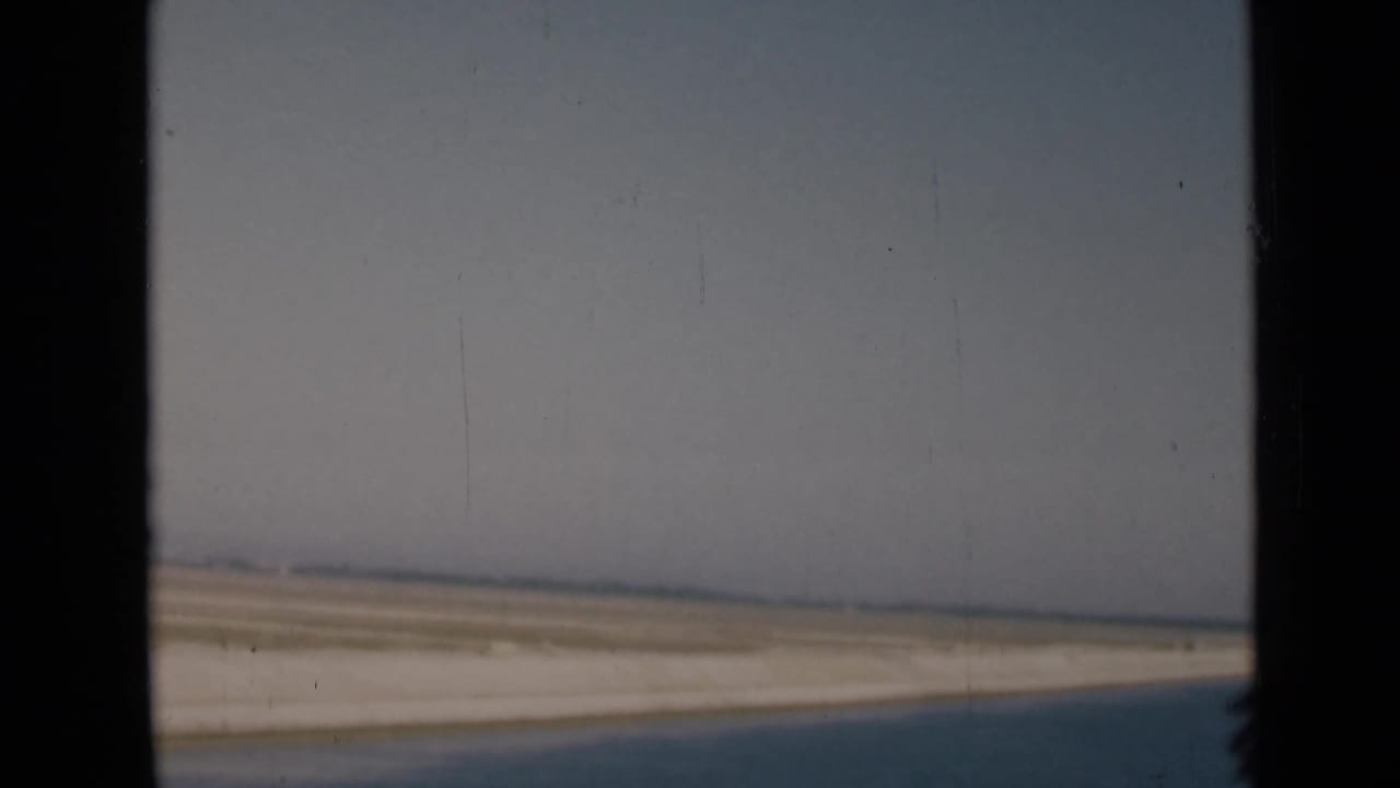 1946 Egypt travel footage showing a hazy desert horizon and darker canal-side or roadside foreground from a vehicle window.