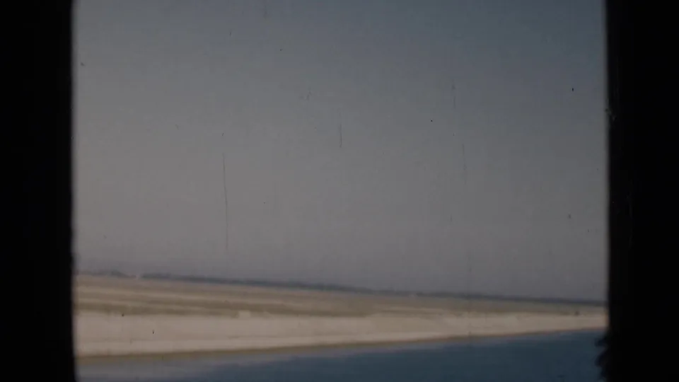 1946 Egypt travel footage showing a hazy desert horizon and darker canal-side or roadside foreground from a vehicle window.