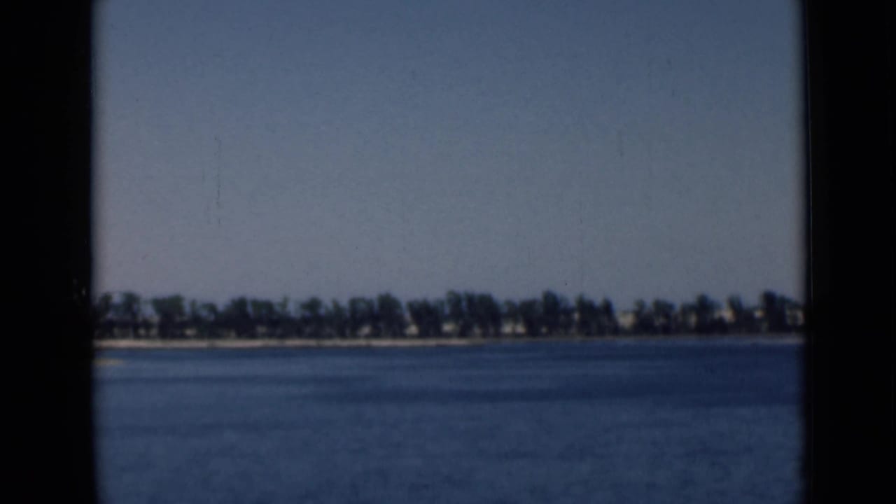 Wide 8mm view of calm water and a distant shoreline near the Suez Canal area in 1946.