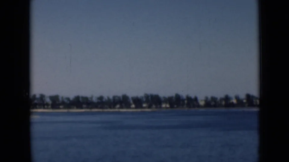 Wide 8mm view of calm water and a distant shoreline near the Suez Canal area in 1946.