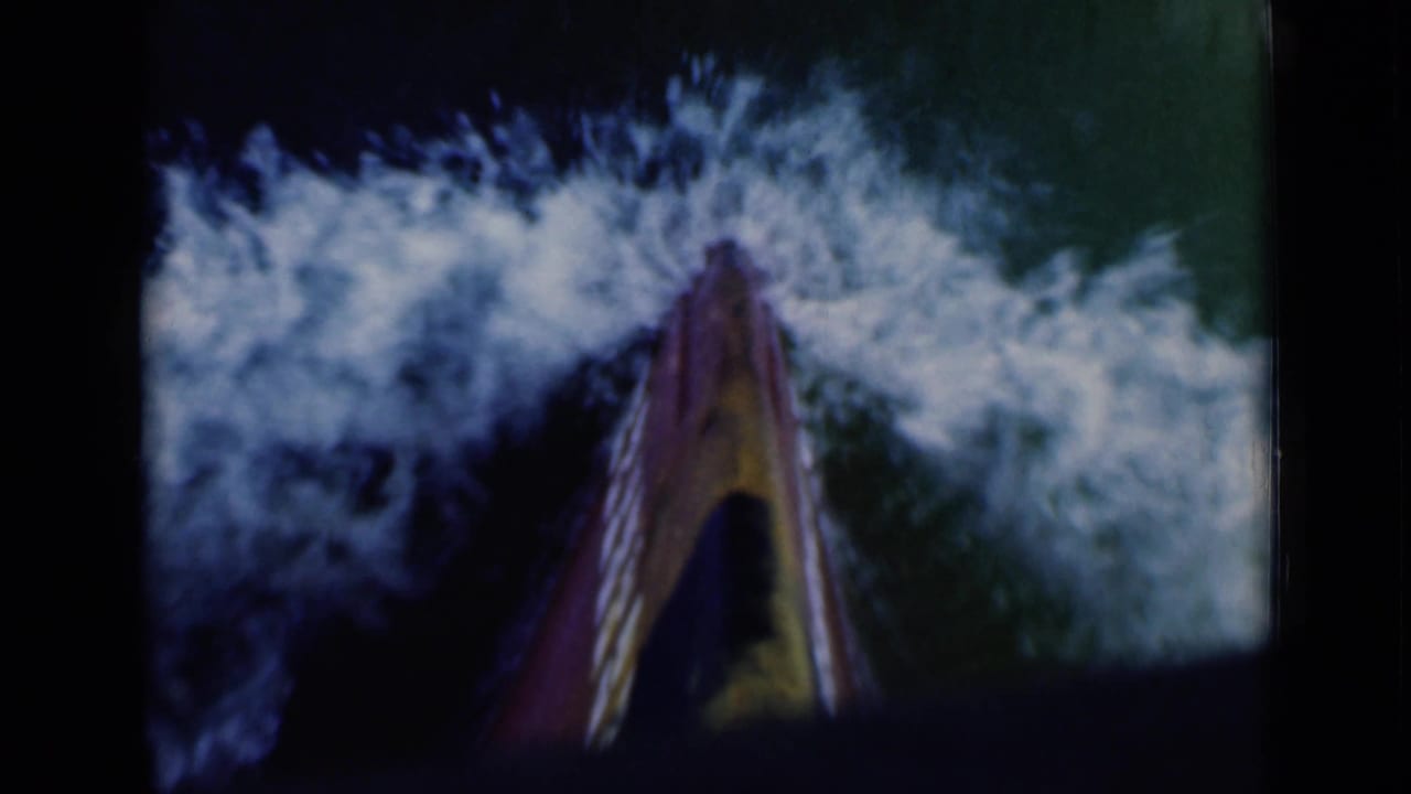 The boat prow cuts through water, throwing white wake to both sides in 1946 8mm footage near Suez Canal, Egypt.