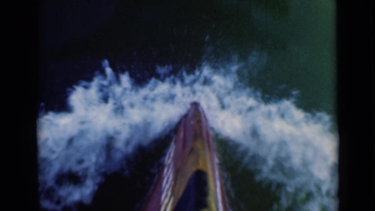1946 8mm frame showing a first-person board-level view moving through foamy surf near the Suez Canal, Egypt.
