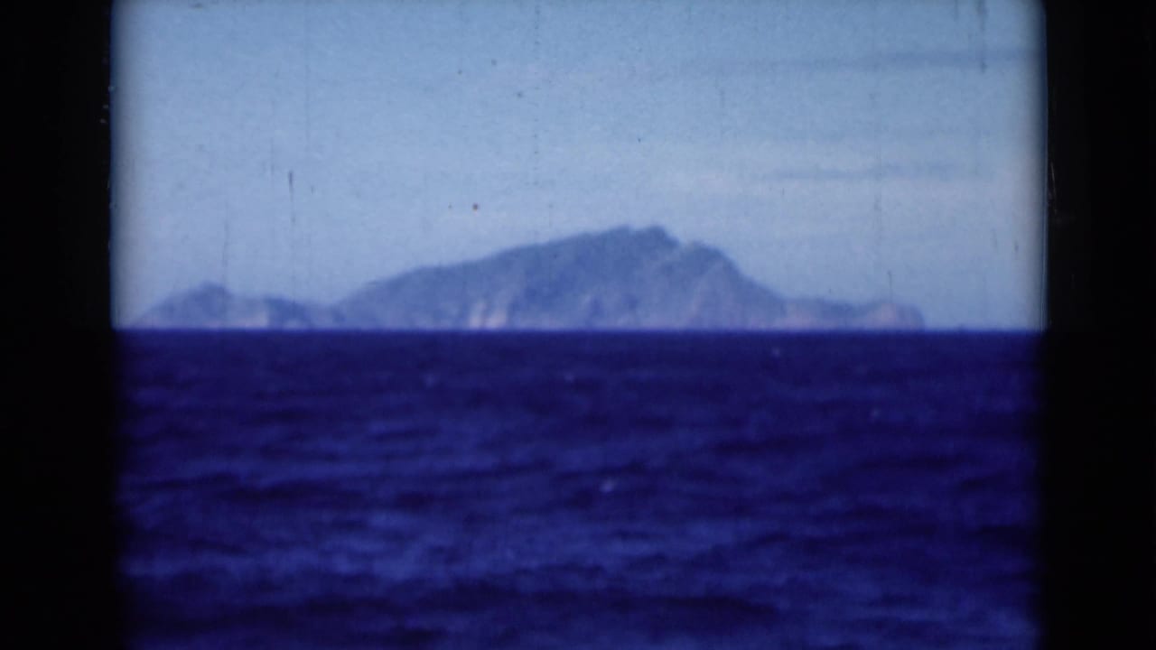 A soft 8mm view shows deep blue water and a distant coastal landmass, likely filmed from the Suez Canal area in 1946.